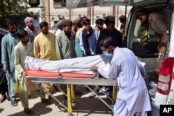 Volunteers and relatives load the body of a passenger, who was killed by gunmen on a highway in Musakhail, into an ambulance after collecting it from a hospital, in Quetta, Pakistan, Aug. 26, 2024.