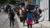 Una residente abandona la comuna de Carrefour Feuilles en Puerto Príncipe el 15 de agosto de 2023, mientras la violencia de pandillas continúa golpeando la capital de Haití