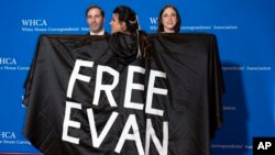 Wall Street Journal journalist Vivian Salama displays a cape with the name of her colleague WSJ correspondent Evan Gershkovich, who is detained in Russia, at the annual White House Correspondents' Association Dinner in Washington, April 29, 2023. 