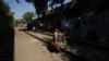 A migrant from Maracaibo, Venezuela, sits on a railroad track lined by makeshift tents where migrants take refuge in Mexico City, March 26, 2024. 