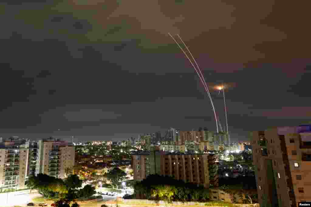 A trail of smoke is seen as rockets from Gaza are intercepted in the early morning, as seen from Ashkelon, Israel.