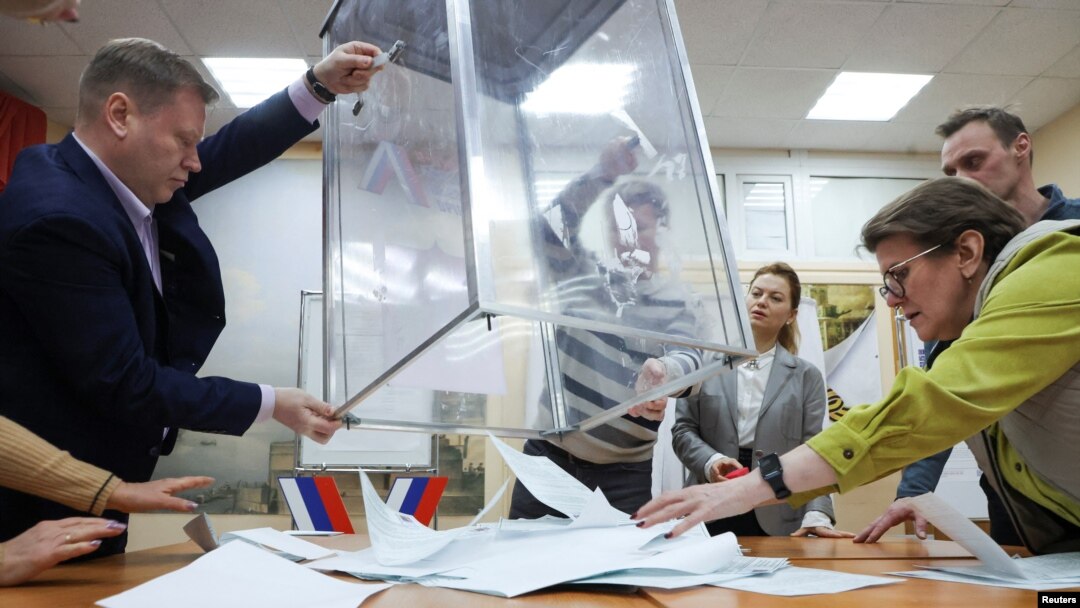 Members of a local electoral commission empty a ballot box, after polling stations closed on the final day of Russia's presidential election, in St. Petersburg, March 17, 2024.