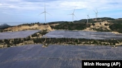 Solar panels work near wind turbines in Quy Nhon, Vietnam on June 11, 2023. Vietnam has released a long-anticipated energy plan meant to take the country through the next decade and help meet soaring demand while reducing carbon emissions. (AP Photo/Minh Hoang)