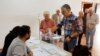 A man helps his mother to cast her vote at a polling station during local elections, in Ronda, southern Spain, May 28, 2023.