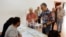 A man helps his mother to cast her vote at a polling station during local elections, in Ronda, southern Spain, May 28, 2023.