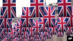 ARCHIVO - Banderas británicas cuelgan sobre Regent Street antes de la coronación del rey Carlos III de Gran Bretaña, en Londres, el jueves 27 de abril de 2023.