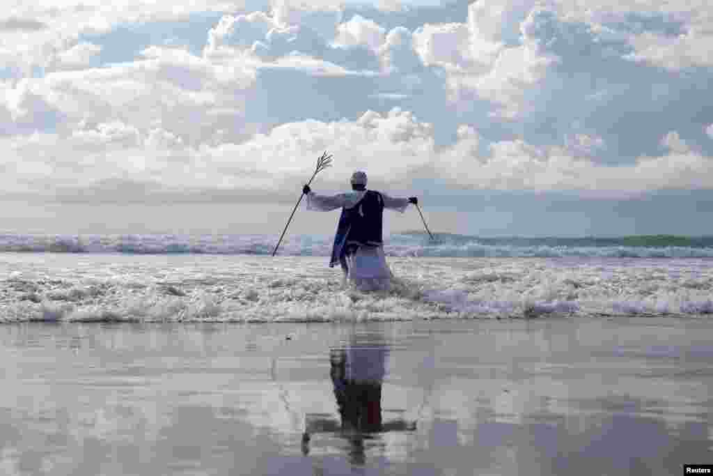 A person takes part in a baptism in the ocean on Good Friday in Durban, South Africa.