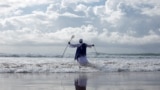 A person takes part in a baptism in the ocean on Good Friday in Durban, South Africa.