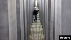 A visitor walks at the Holocaust Memorial to the Murdered Jews of Europe as Germany commemorates the victims of the Holocaust on the eve of the International Holocaust Remembrance Day, in Berlin, Germany, Jan. 26, 2024.