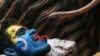 A Hindu devotee holds a snake during a religious procession on the occasion of 'Masaan' or 'Bhasma' Holi, which is celebrated with ashes of funeral pyres, in Varanasi, India, March 20, 2024.