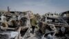 A Palestinian man walks between scorched cars in a scrapyard, in the town of Hawara, near the West Bank city of Nablus, Feb. 27, 2023. 