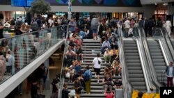 Los viajeros se sientan en las escaleras de la Gare de Montparnasse, en los Juegos Olímpicos de Verano de 2024, el viernes 26 de julio de 2024, en París, Francia.