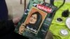 FILE - A person holds a copy of Iranian magazine Andisheh reporting on the death of Mahsa Amini, who died after being arrested by the Islamic republic's "morality police," in Tehran, Iran, March 14, 2023.