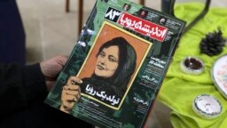 FILE - A person holds a copy of Iranian magazine Andisheh reporting on the death of Mahsa Amini, who died after being arrested by the Islamic republic's 
