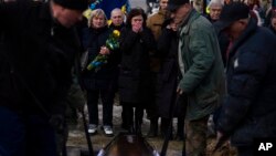 Kateryna, center, the mother of soldier Denys Averiiev, 32, reacts during the funeral of her son at Lviv cemetery, western Ukraine, on Feb. 23, 2023. Averiiev died in Bakhmut on Feb. 16, 2023.