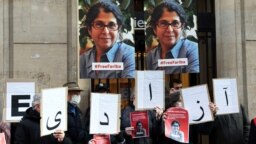 FILE - In this Jan. 13, 2022 photo, colleagues of academic Fariba Adelkhah hold placards in Paris in support following Iran's decision to send her back to prison after a period of house arrest. On Feb. 10, 2023, she was released from prison. 