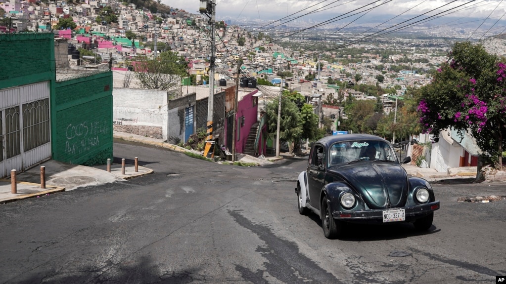 Janette Navarro drives her 1996 Volkswagen Beetle up a steep hill in the Cuautepec neighborhood of Mexico City, Friday, June 21, 2024. (AP Photo/Aurea Del Rosario)