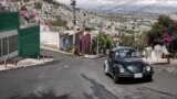 Janette Navarro drives her 1996 Volkswagen Beetle up a steep hill in the Cuautepec neighborhood of Mexico City, Friday, June 21, 2024. (AP Photo/Aurea Del Rosario)