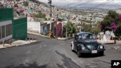 Janette Navarro drives her 1996 Volkswagen Beetle up a steep hill in the Cuautepec neighborhood of Mexico City, Friday, June 21, 2024. (AP Photo/Aurea Del Rosario)