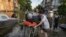 Volunteers haul a woman on a stretcher as she was being evacuated from a flooded neighborhood of the left bank of the Dnipro River, in Kherson, Ukraine, June 9, 2023.