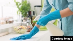 Woman cleaning with a spray detergent