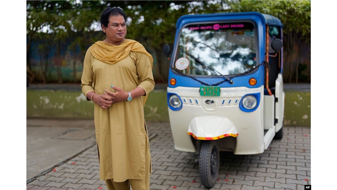 Preethi, perempuan transgender berusia 38 tahun, berdiri di samping becak listriknya saat diwawancarai The Associated Press di Bengaluru, India, Senin, 10 Juli 2023. (AP/Aijaz Rahi)
