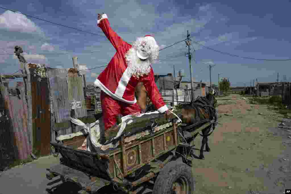 Tito Perez, dengan kostum ala sinterklas, menyapa anak-anak di sebuah area di Buenos Aires, Argentina, pada 23 Desember 2023. (Foto: AP/Rodrigo Abd)