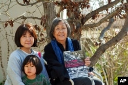 Kathy Masaoka poses with her daughter, Mayumi, and her grandson, Yuma, outside her home in Los Angeles, Feb. 12, 2023.