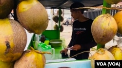 Andry Araque, vendedor de cocos, repasa sus ganancias en bolívares y dólares la mañana de este miércoles, en Maracaibo, Venezuela.