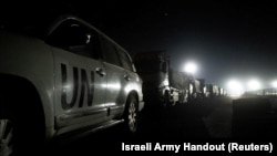 Trucks containing humanitarian aid from the World Food Program are parked in a location given as northern Gaza Strip, in this handout image released on March 12, 2024. 
