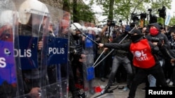 Protesters scuffle with riot police as they attempt to defy a ban and march on Taksim Square to celebrate May Day in Istanbul, May 1, 2024.