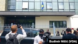 Novinari ispred zgrade Skupštine opštine Severna Mitrovica tokom postavljanja zastave