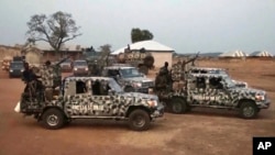 In this screen grab taken from video, Nigerian Army vehicles are parked at the village where children were kidnapped in Kuriga, Kaduna state, March 7, 2024. 