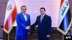 In this handout photo released by Iraq's National Security Council press office, Iraq's National Security Adviser Qasim al-Araji (R) welcomes the Secretary of Iran's Supreme National Security Council Ali Shamkhani, in Baghdad, Iraq, March 19, 2023.