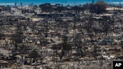 FILE - Charred remains of homes are visible following a wildfire in Lahaina, Hawaii, Aug. 22, 2023.