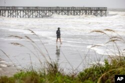 Jergen Wagner of Charleston, S.C., braves the wind and rain on the beach in Isle of Palms, S.C., as Tropical Storm Debby approaches, Aug. 6, 2024.