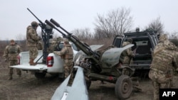 FILE - Air Defense Ukrainian servicemen, who took part in the defense operations during recent attacks on Kyiv, prepare their weapons near Kyiv, Jan. 3, 2024. Ukraine said Monday its air defenses downed eight drones launched by Russia.