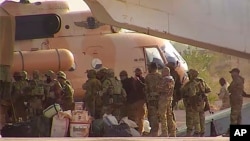 FILE - This undated photograph provided by the French military shows Russian mercenaries boarding a helicopter in northern Mali. 