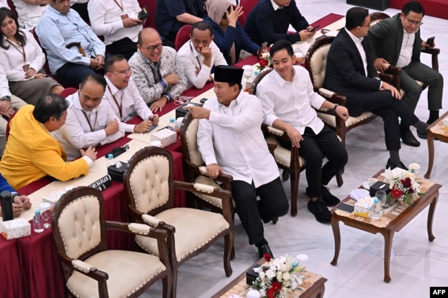 Presiden terpilih Prabowo Subianto berbincang dengan sejumlah politisi dari koalisi partai yang mendukungnya saat acara penetapan hasil pilpres 2024 di Komisi Pemilihan Umum (KPU) di Jakarta, 24 April 2024. (Foto: Adek Berry/AFP)