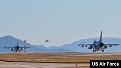 ແຟ້ມພາບ: ເຮືອບິນລົບ F-16 Fighting Falcons ຂອງກອງທັບອາກາດສະຫະລັດ ສອງລຳ ກຳລັງກຽມພ້ອມທີ່ບິນຂຶ້ນ ຂະນະທີ່ ເຮືອບິນລົບ F-16 ຂອງເກົາຫຼີໃຕ້ ບິນລົງເດີ່ນຜ່ານໄປ ໃນລະຫວ່າງການຊ້ອມລົບປະຈຳປີ 2023 ຢູ່ທີ່ ຖານທັບອາກາດ ຄຸນຊານ (Kunsan Air Base), ວັນທີ 2 ພະຈິກ 2022. 