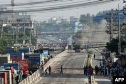 Sebuah truk kargo dibakar massa yang terdiri dari para pekerja garmen yang berunjuk rasa di Shafipur, 31 Oktober 2023, menuntut upah yang adil. (Munir uz zaman / AFP)