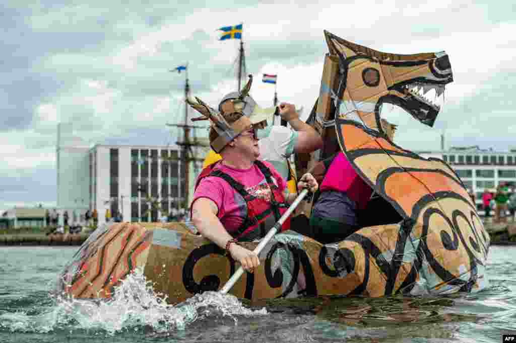 Para peserta berlomba dalam Great Salem Maritime Cardboard Boat Regatta sebagai bagian dari lomba dayung perahu dari kardus di Salem, Massachusetts. (AFP)&nbsp;