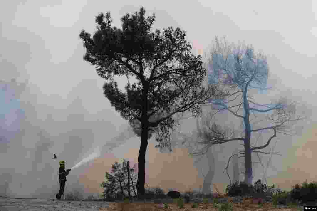 A Czech firefighter extinguishes a wildfire burning near the village of Provatonas in the region of Evros, Greece.