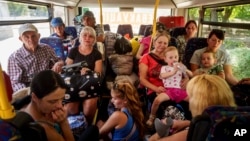 People sit in a bus during an evacuation from Pokrovsk, Donetsk region, Ukraine, Aug. 19, 2024.