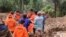 This handout photo released on April 14, 2024 by the National Search and Rescue Agency (BASARNAS) shows rescuers carrying a body bag at a landslide site in Tana Toraja, South Sulawesi. 