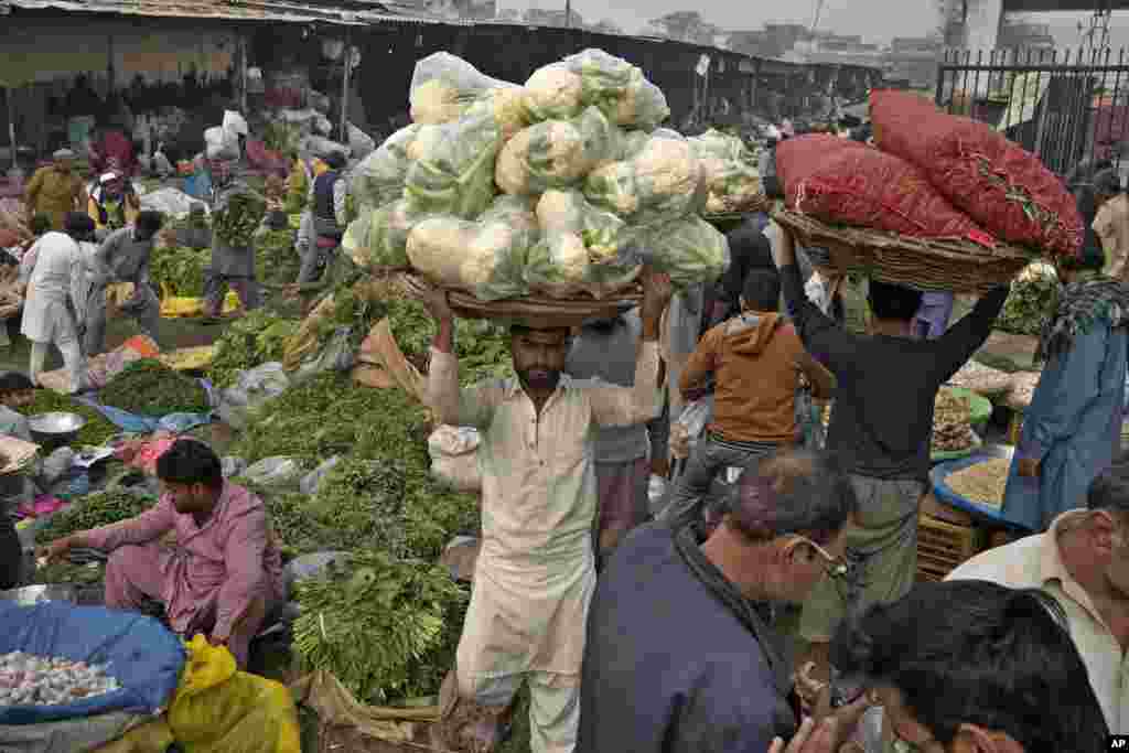 Laborers work at a large vegetable and fruit market in Lahore, Pakistan.