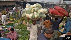 Laborers work at a wholesale vegetable and fruit market in Lahore, Pakistan.