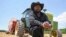 FILE - Farmer John Boyd Jr., poses for a portrait during a break from baling hay at his farm in Boydton, Va., May 27, 2021. 