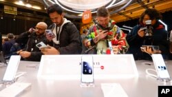 Visitors take pictures of Xiaomi 13 mobile phone models at the Xiaomi booth before the Mobile World Congress 2023 in Barcelona, Spain, on Feb. 26, 2023.