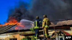 FILE -Firefighters pushing out a fire in a warehouse after shelling in Kherson, Sept. 19, 2023. (AFP photo / Handout / Ukrainian Emergency Service)